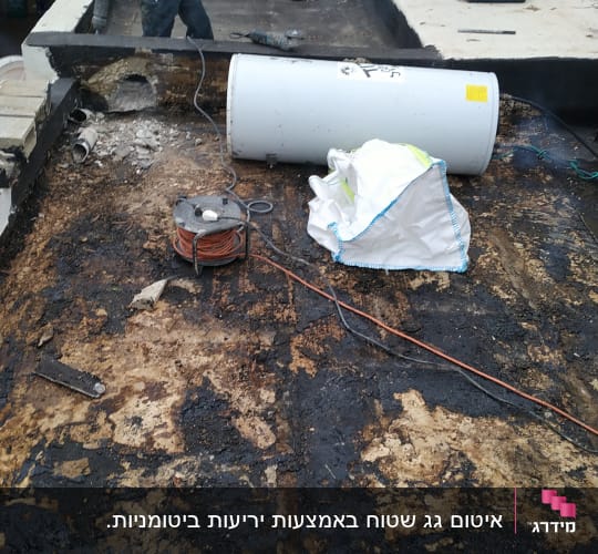 עובד עם כלי עבודה על גג לאיטום